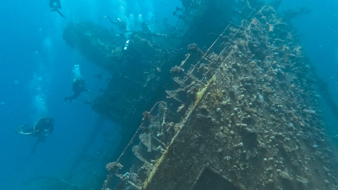 A diver exploring the hull of a sunken WWII shipwreck at Coron, Palawan
