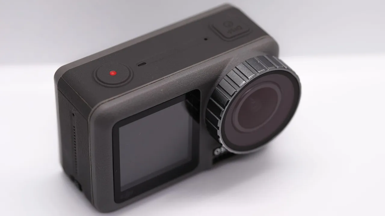 A DJI Osmo Action in a dive housing with a red filter, filming a reef, its screen showing depth