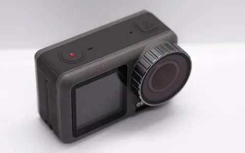 A DJI Osmo Action in a dive housing with a red filter, filming a reef, its screen showing depth