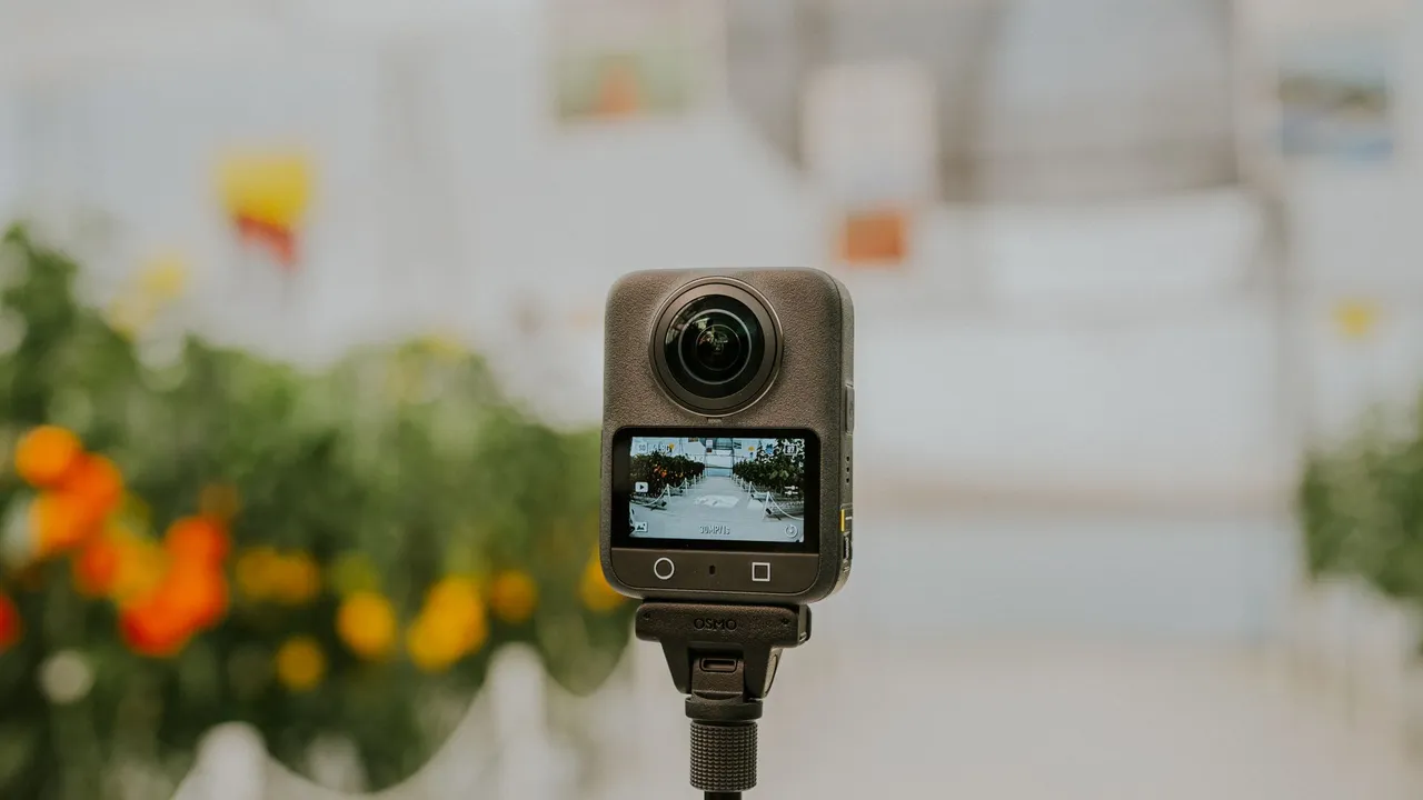 An Insta360 360-degree camera on an invisible selfie stick filming a diver over a reef