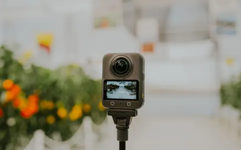 An Insta360 360-degree camera on an invisible selfie stick filming a diver over a reef